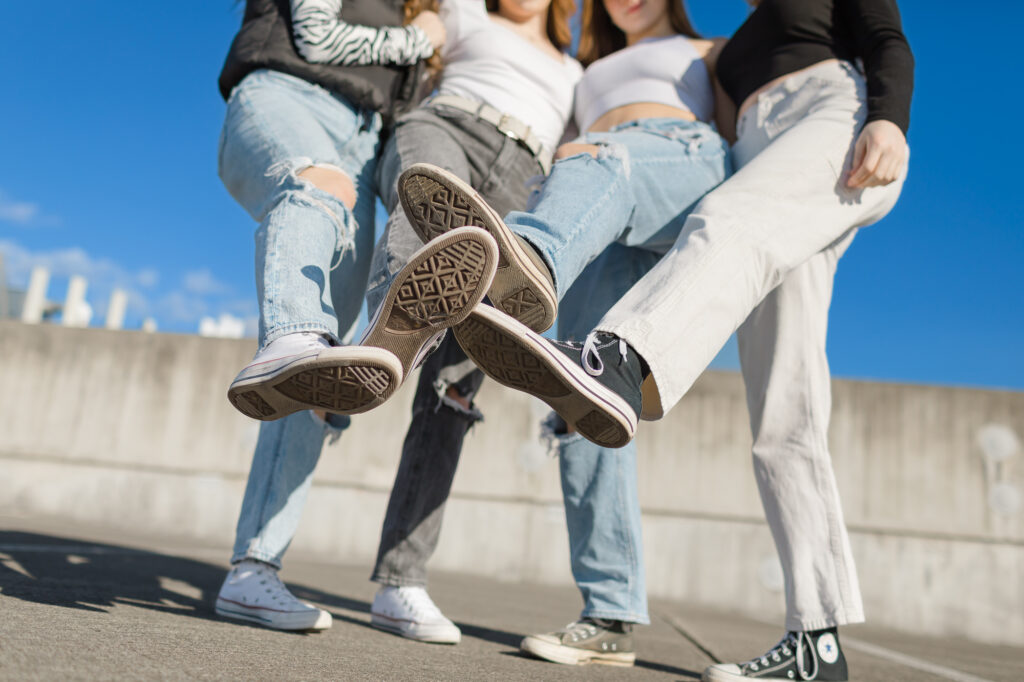 Group of female high school age friends on a rooftop with converse on.