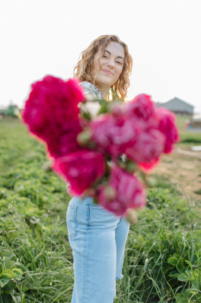 Peonies blurred and the focus on the female senior holding them.