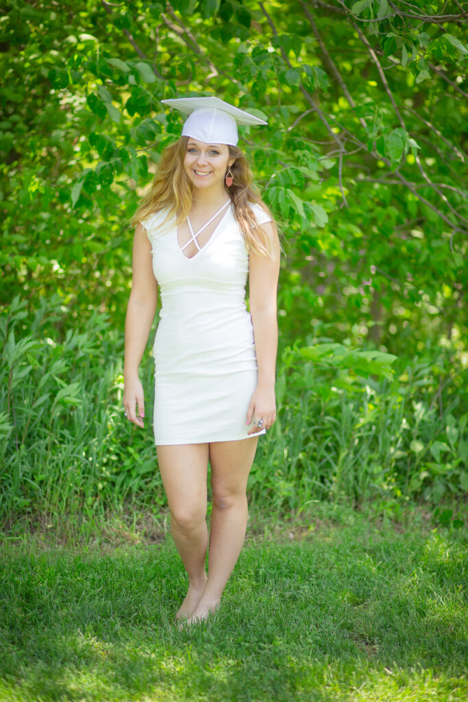 High School Senior in her cap & gown and white dress for graduation day.