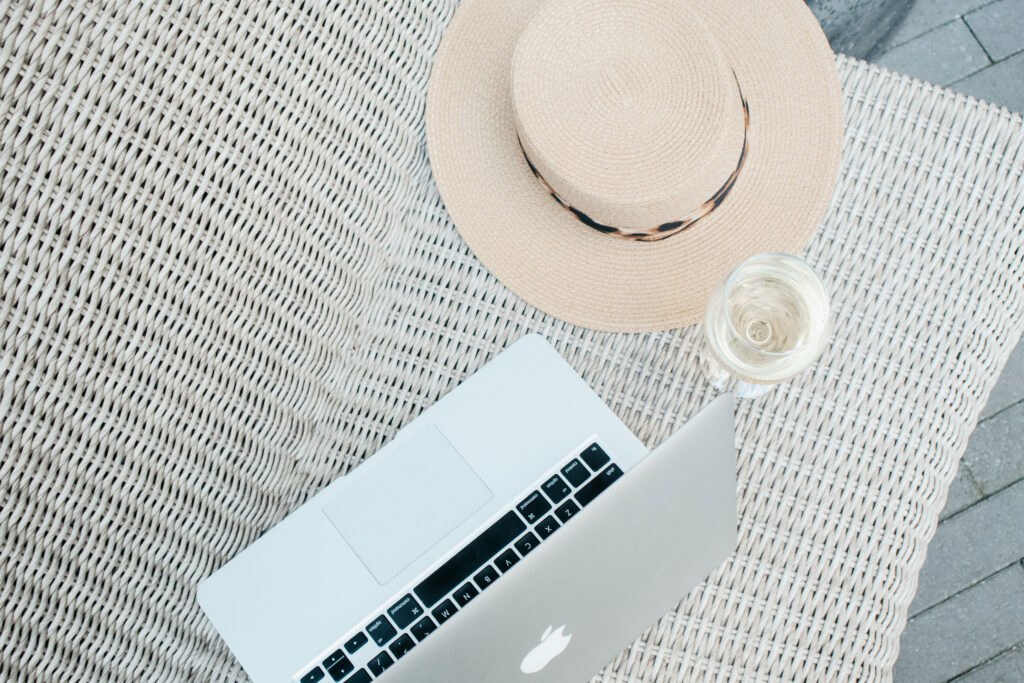 Vacation image with a sun hat and Macbook