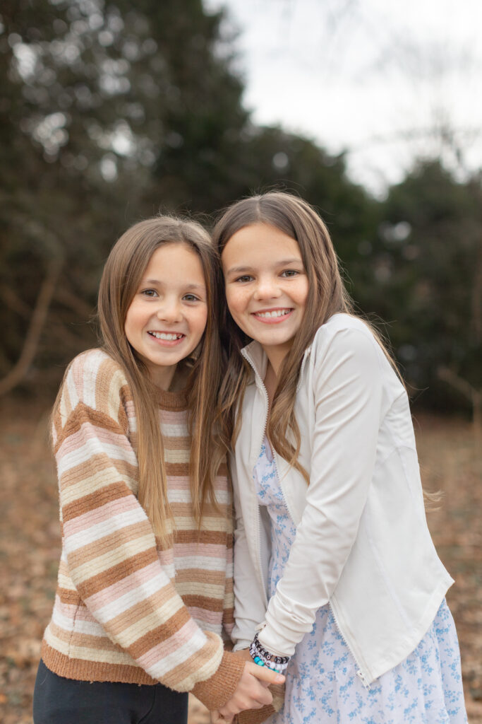 Tween girls holding hands looking at the camera smiling. | 10 FAQ's for a Photo Session